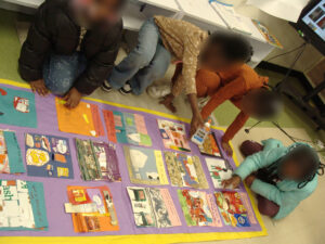 Paper quilt squares assembled onto brightly colored bulletin paper.